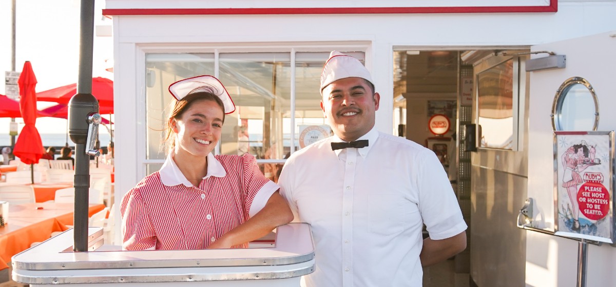 Two smiling team members standing outside a Ruby's location