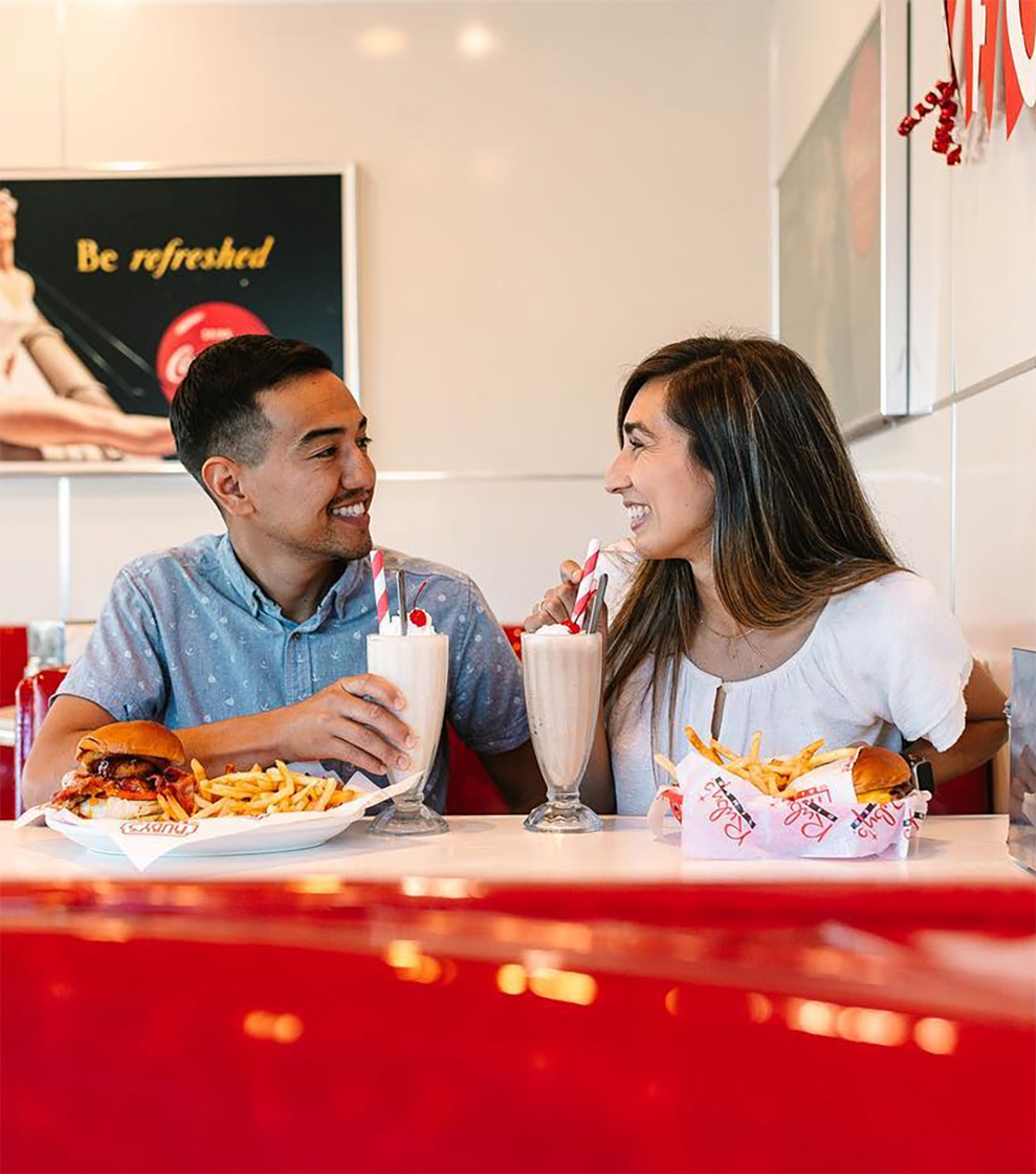 A young couple enjoying a meal in a booth